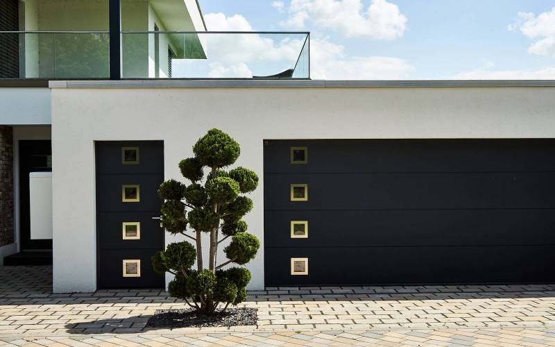 Porte d'entrée sécurisée et isolante en harmonie avec la porte de garage